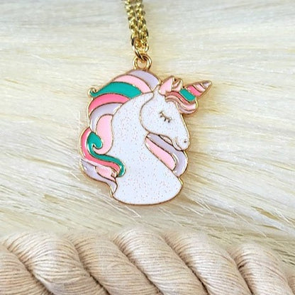 Charming unicorn pendant showcasing glimmering pastel hues and glittery accents, delicately dangling from a golden chain, set against a silky backdrop.