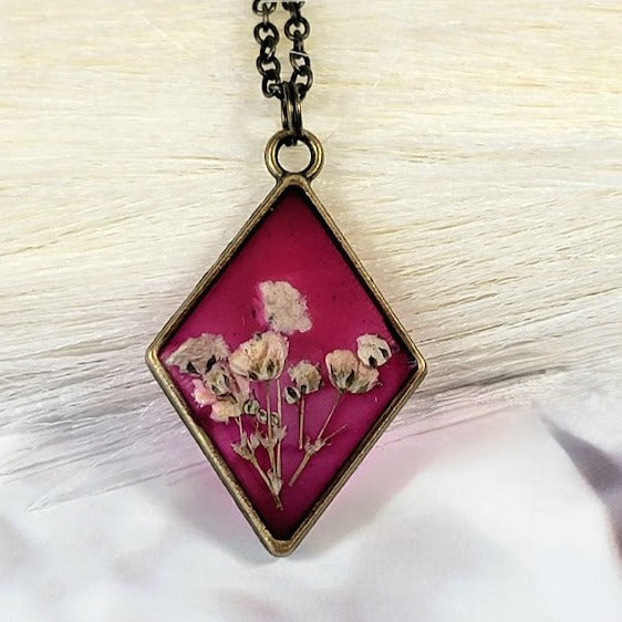 Vintage-Inspired Floral Necklace, Handpicked White Carnation Jewelry, Diamond-Shaped Resin Pendant, Dark Pink Backdrop Charm, Eco-Friendly