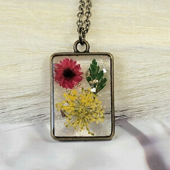 Collar inspirado en la pradera iluminada por el sol, arte de resina de flora hecho a mano, colgante de aliento de bebé amarillo, encanto de capullo de clavel rojo, joyería inspirada en la naturaleza