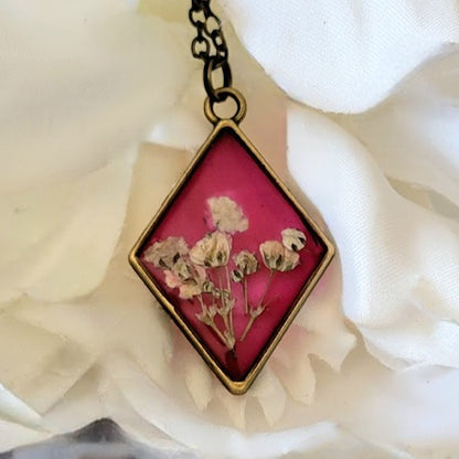 Vintage-Inspired Floral Necklace, Handpicked White Carnation Jewelry, Diamond-Shaped Resin Pendant, Dark Pink Backdrop Charm, Eco-Friendly