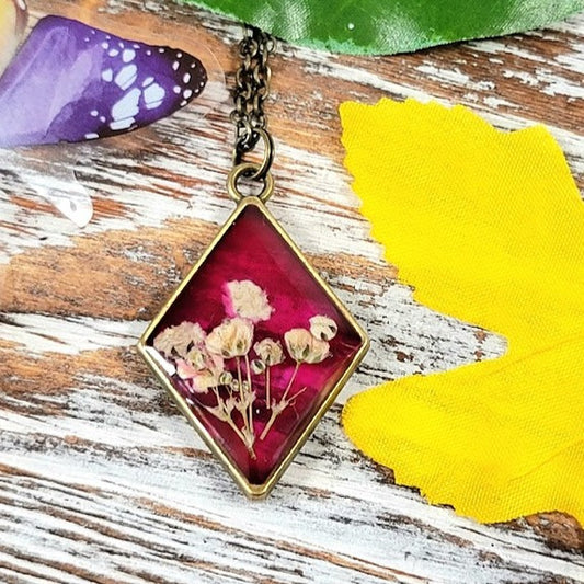 Vintage-Inspired Floral Necklace, Handpicked White Carnation Jewelry, Diamond-Shaped Resin Pendant, Dark Pink Backdrop Charm, Eco-Friendly