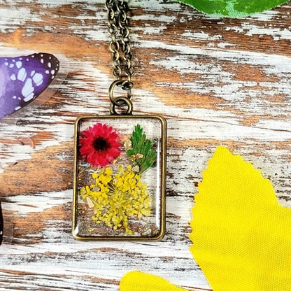 Collar inspirado en la pradera iluminada por el sol, arte de resina de flora hecho a mano, colgante de aliento de bebé amarillo, encanto de capullo de clavel rojo, joyería inspirada en la naturaleza