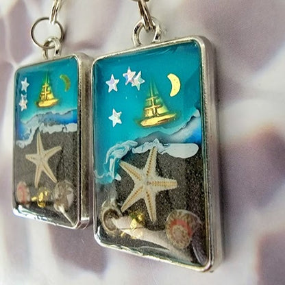 Voilier en or sur boucles d’oreilles en toile de fond bleue, bijoux du ciel nocturne nautique, souvenir de mémoire de plage, nuit étoilée à lunette argentée, ambiance de plage faite à la main