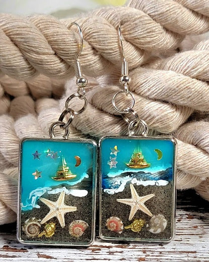 Voilier en or sur boucles d’oreilles en toile de fond bleue, bijoux du ciel nocturne nautique, souvenir de mémoire de plage, nuit étoilée à lunette argentée, ambiance de plage faite à la main