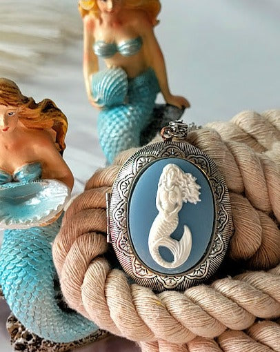 An enchanting silver mermaid cameo pendant with an intricate relief on a calming blue oval exudes the mythical charm and beauty of the sea.