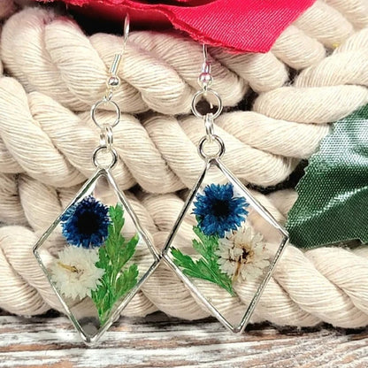 Boucles d’oreilles œillets bleus et blancs, art floral contemporain, feuillage vert luxuriant, pendentif naturellement pressé, printemps intemporel