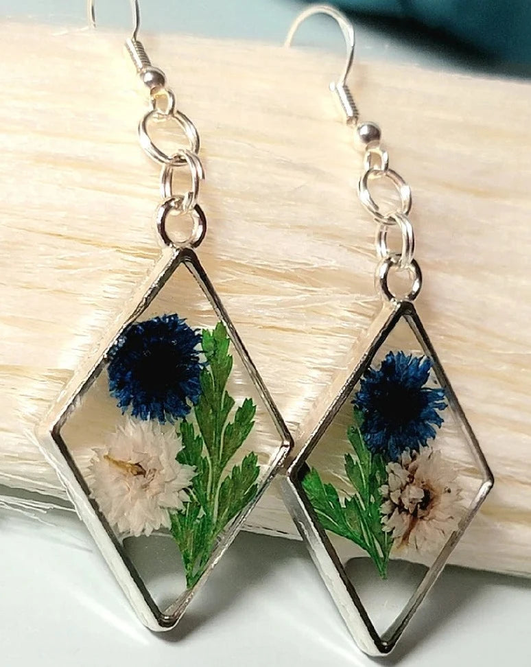 Boucles d’oreilles œillets bleus et blancs, art floral contemporain, feuillage vert luxuriant, pendentif naturellement pressé, printemps intemporel