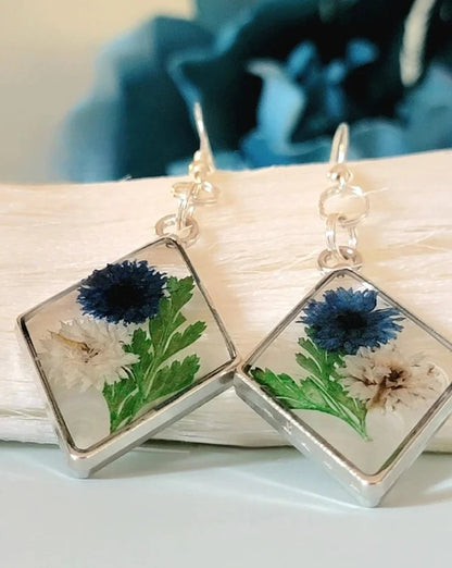 Boucles d’oreilles œillets bleus et blancs, art floral contemporain, feuillage vert luxuriant, pendentif naturellement pressé, printemps intemporel