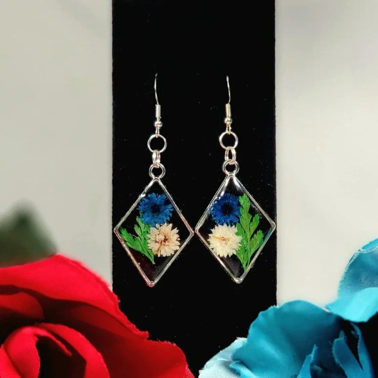 Boucles d’oreilles œillets bleus et blancs, art floral contemporain, feuillage vert luxuriant, pendentif naturellement pressé, printemps intemporel