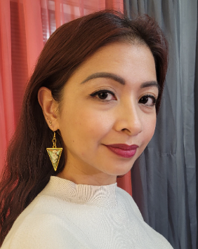 Side profile of a woman in a white sweater, wearing yellow resin triangle earrings with encapsulated white flowers, accentuating her serene elegance.