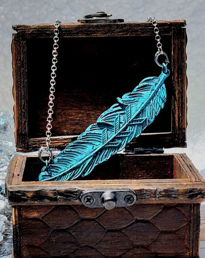 Collier de plumes d’inspiration vintage, pendentif mystique azur patiné, symbole éthéré de liberté et de renaissance, accessoire pour le bohème moderne