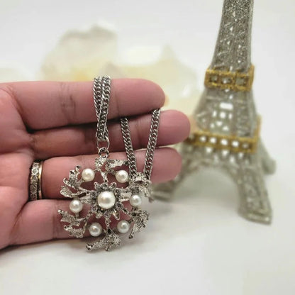 Collier de fleurs en argent, bijoux en perles élégants, élégance intemporelle, accessoire en perles blanches, pendentif floral élégant, chic et sophistiqué